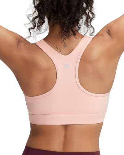 A high-impact racerback sports bra with fixed molded cups and wide elastic straps, dyed in a soft flush pink tone.